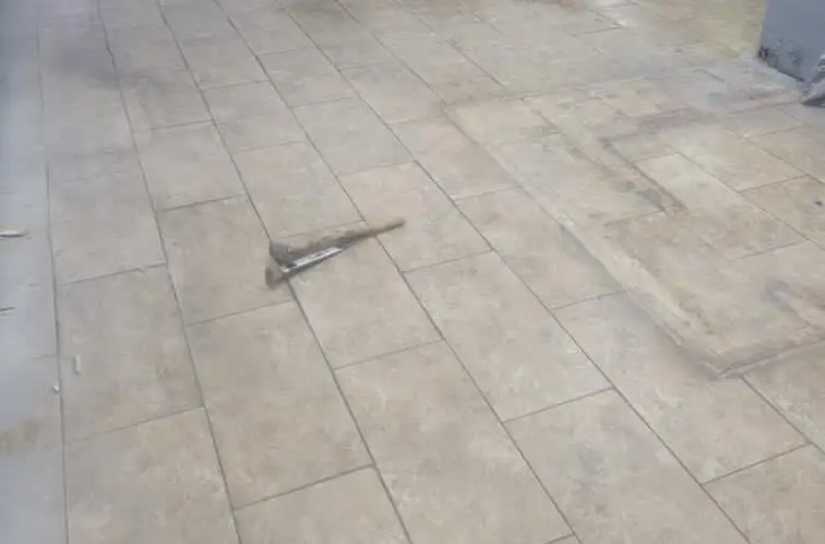 Stamped concrete patio — Poured and stamped patio slab with a tile-pattern finish and cut control joints.