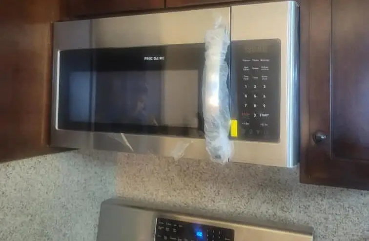 Kitchen appliance & cabinet fit — Over-range microwave and appliance installation with cabinet modification and trim-out.